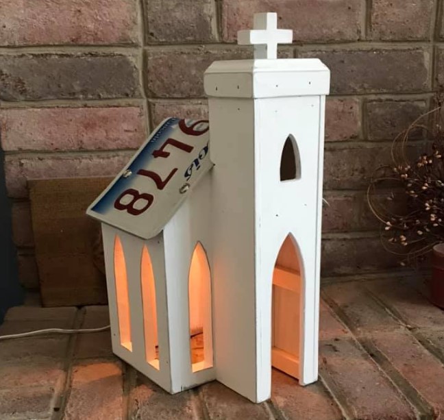 Rustic white antique church with license plate roof.